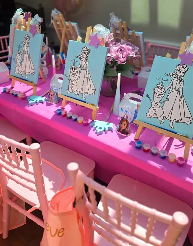 Table setup for kids art birthday party in Toronto with canvas, paints, and craft supplies