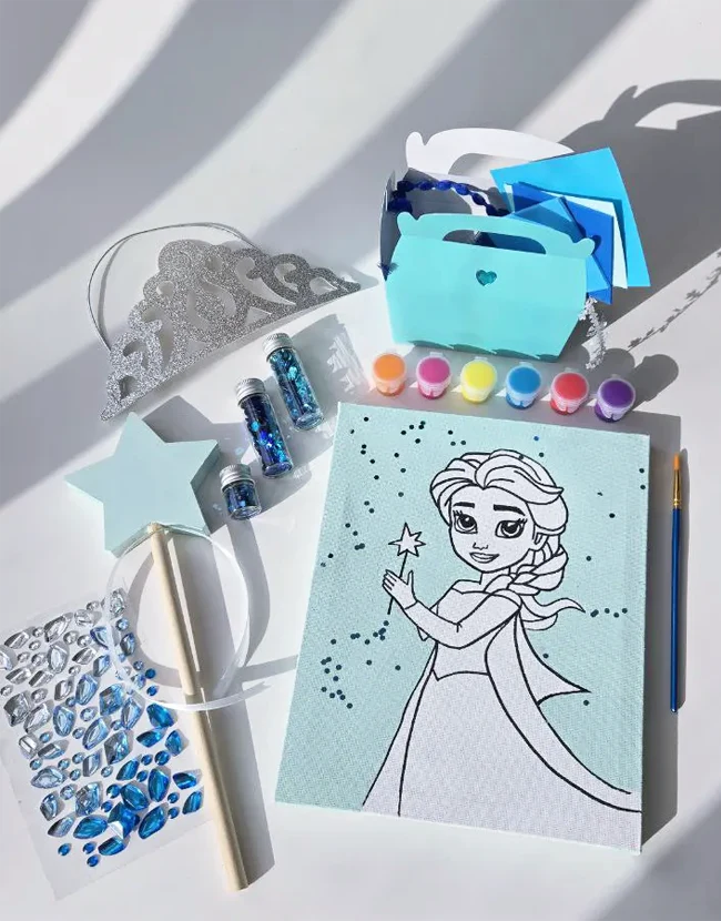 Winter-themed art birthday setup with colouring canvas, paint jars, and star wand decoration